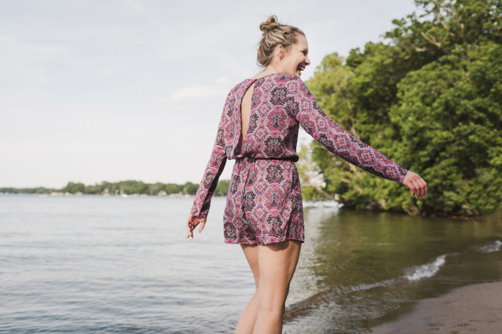 girl in pink romper running into lake