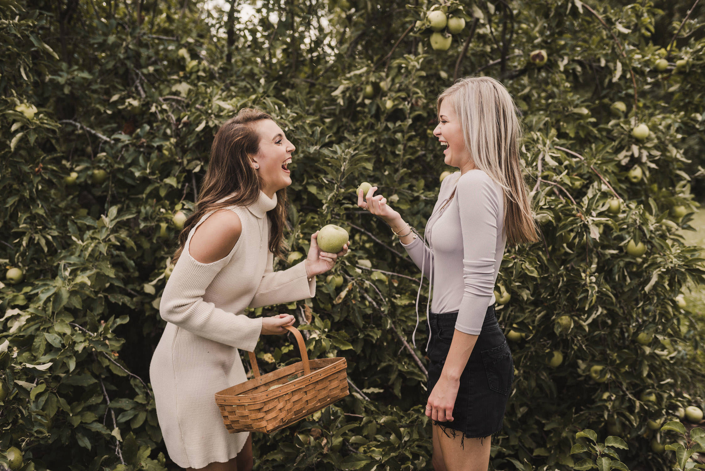 friends laughing in an apple orchard