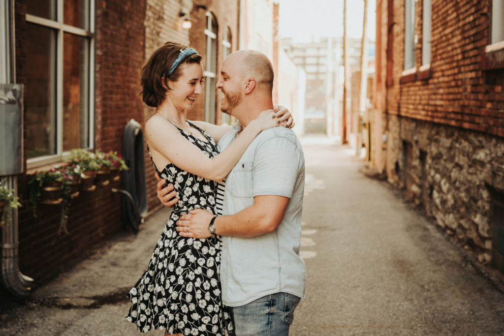 Smiling couple in each others arms in cute alley