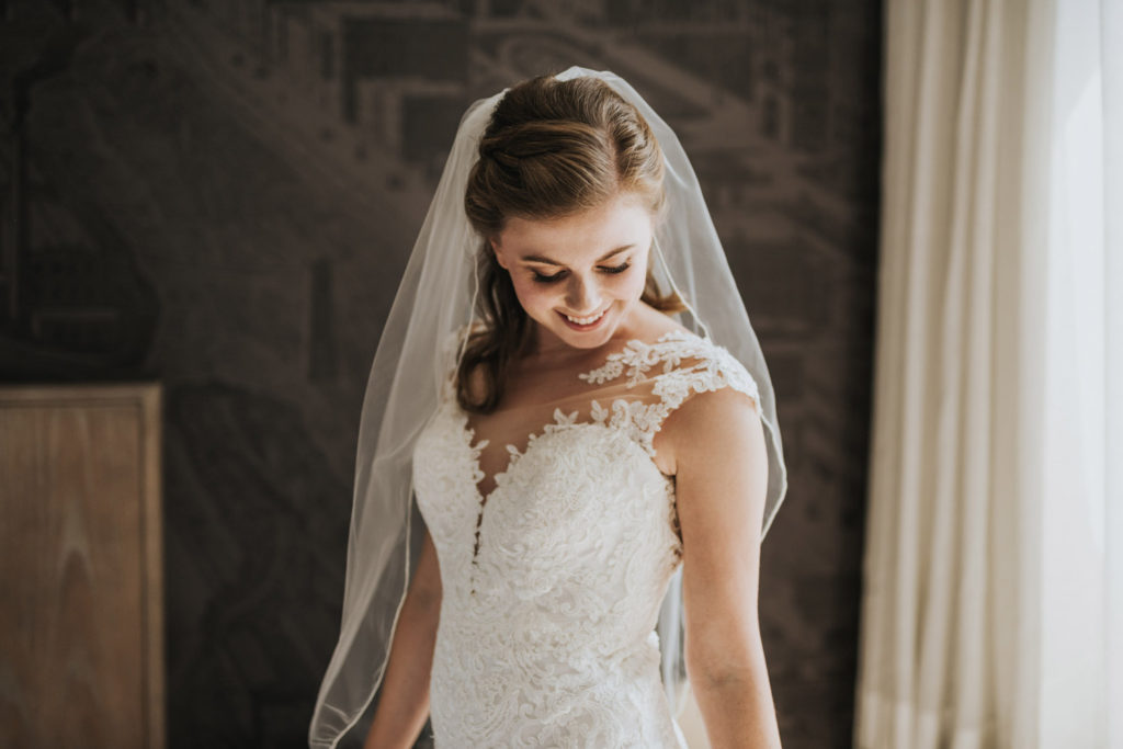 bride smiling just after putting on wedding dress in Minneapolis