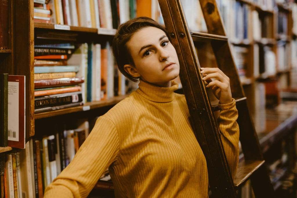 woman model in vintage book store with ladder