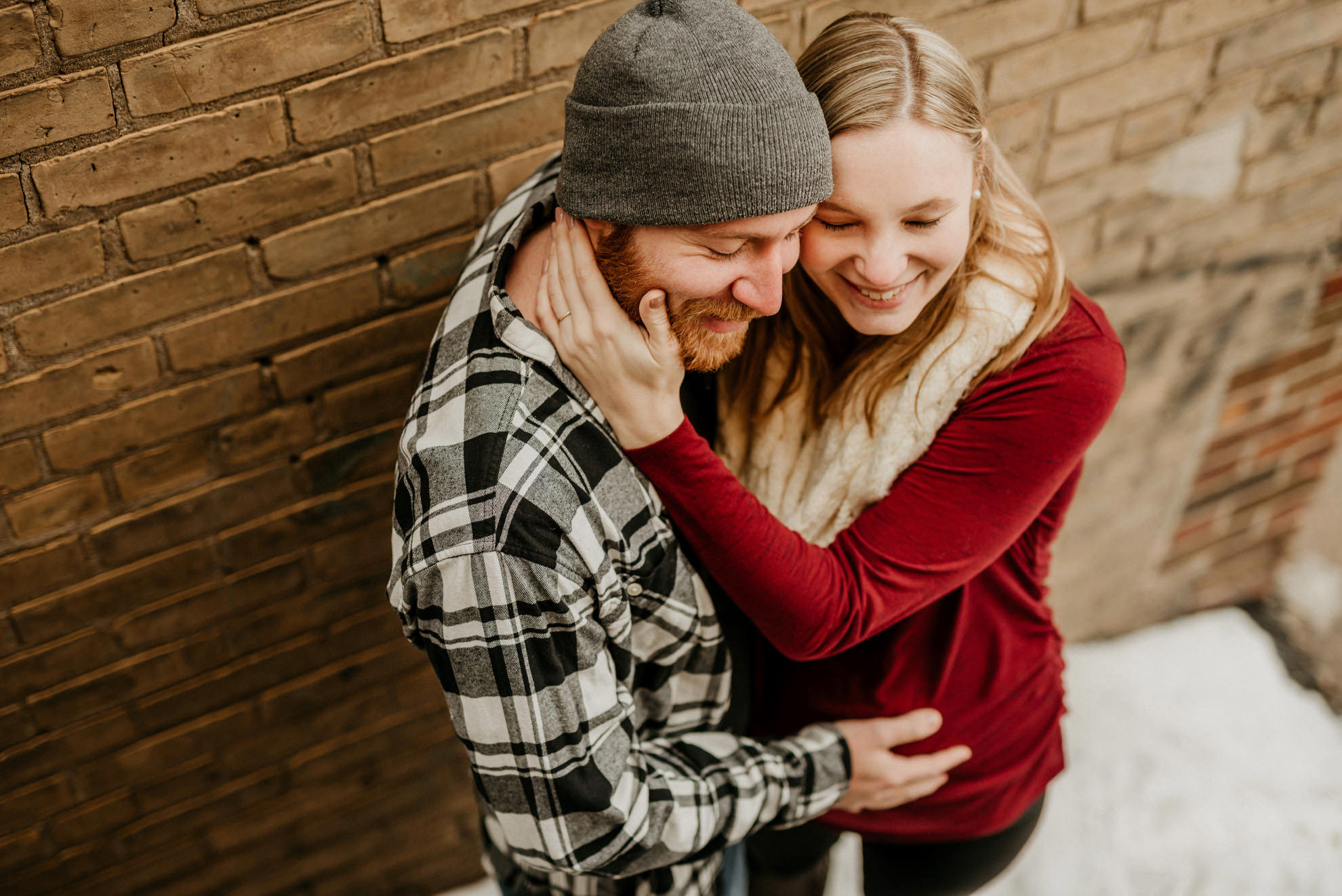 pregnant couple cuddling in alleyway