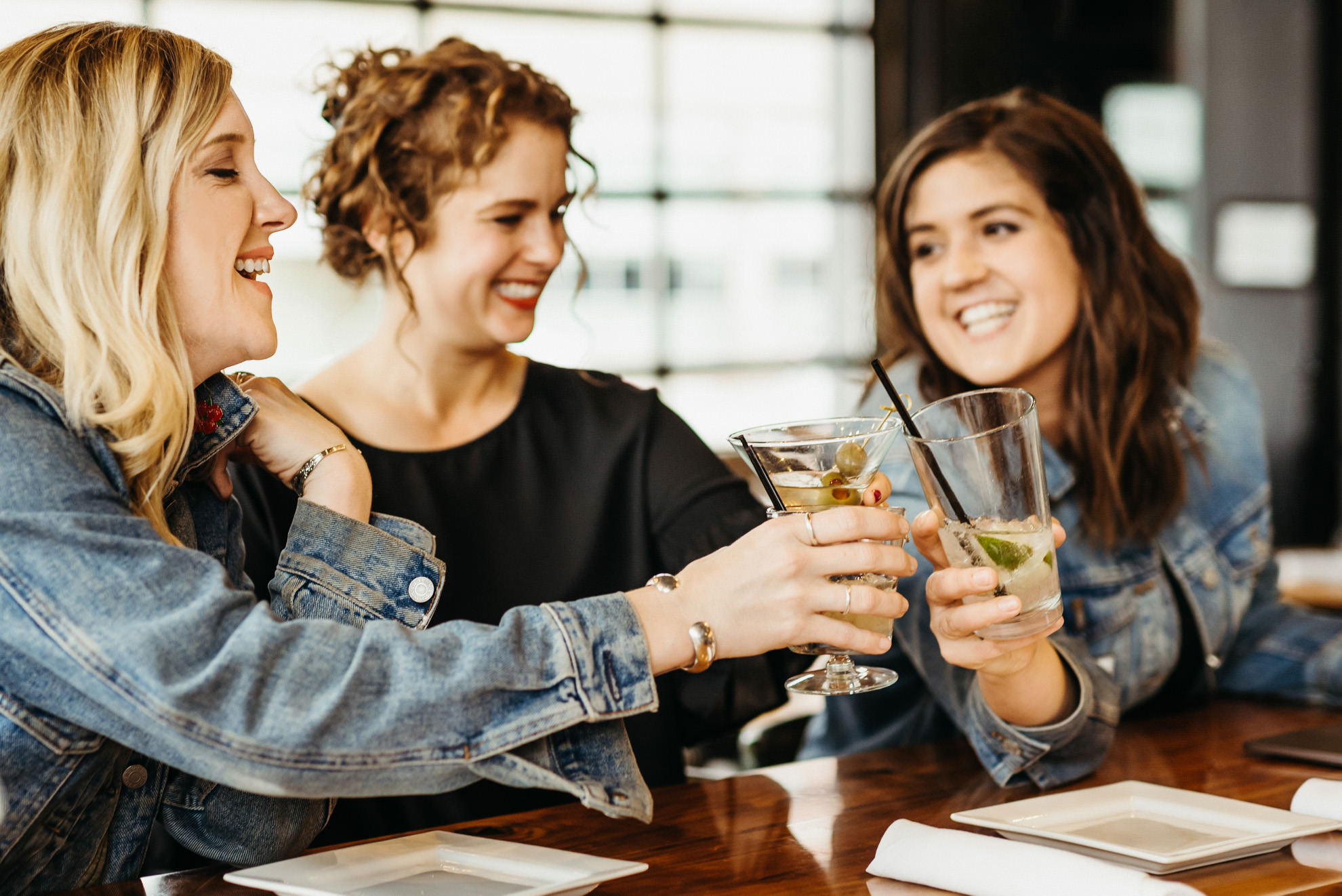 cheers at a bar with three smiling friends