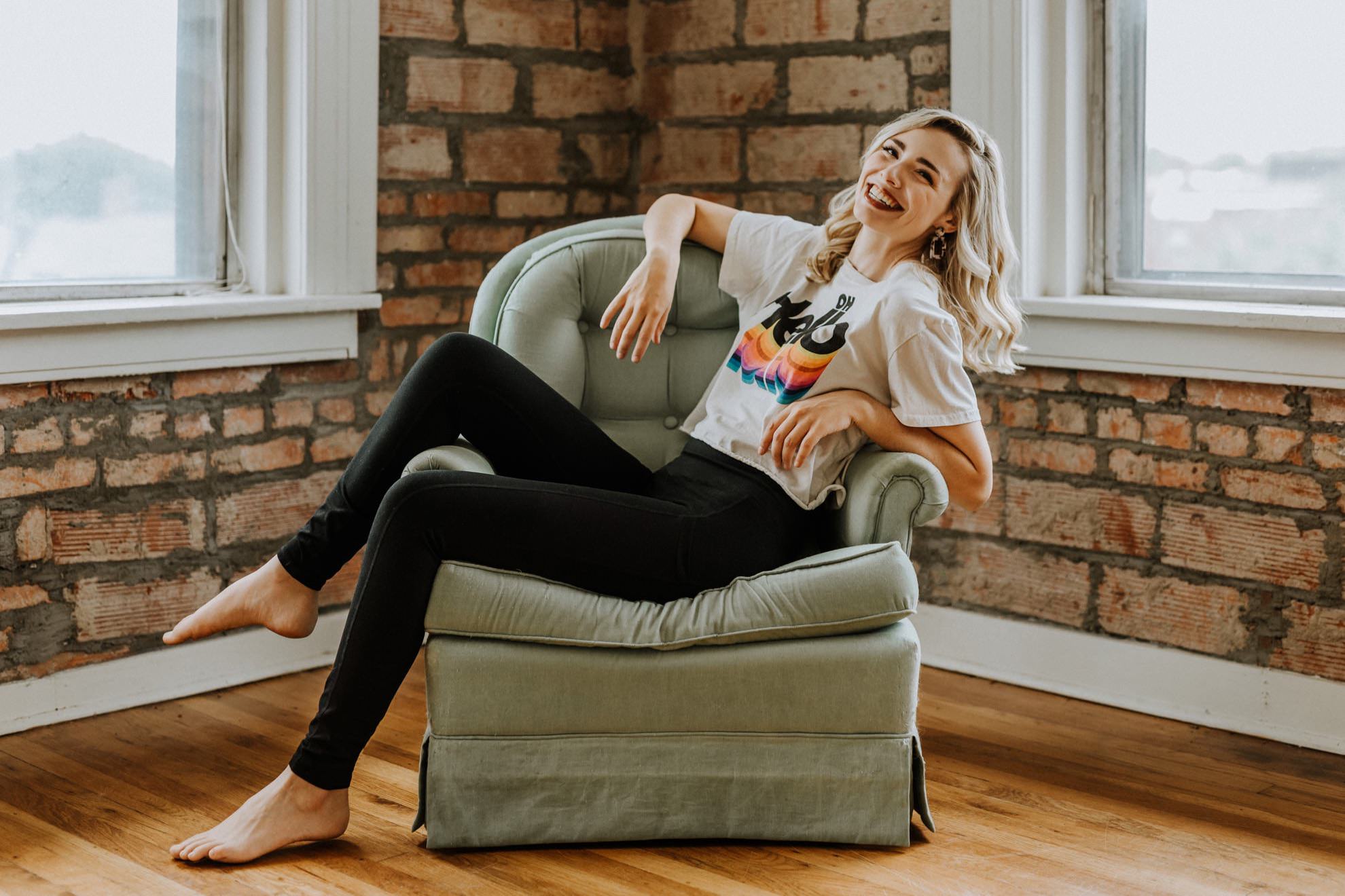 woman lounging on chair wearing shirt that says oh hello