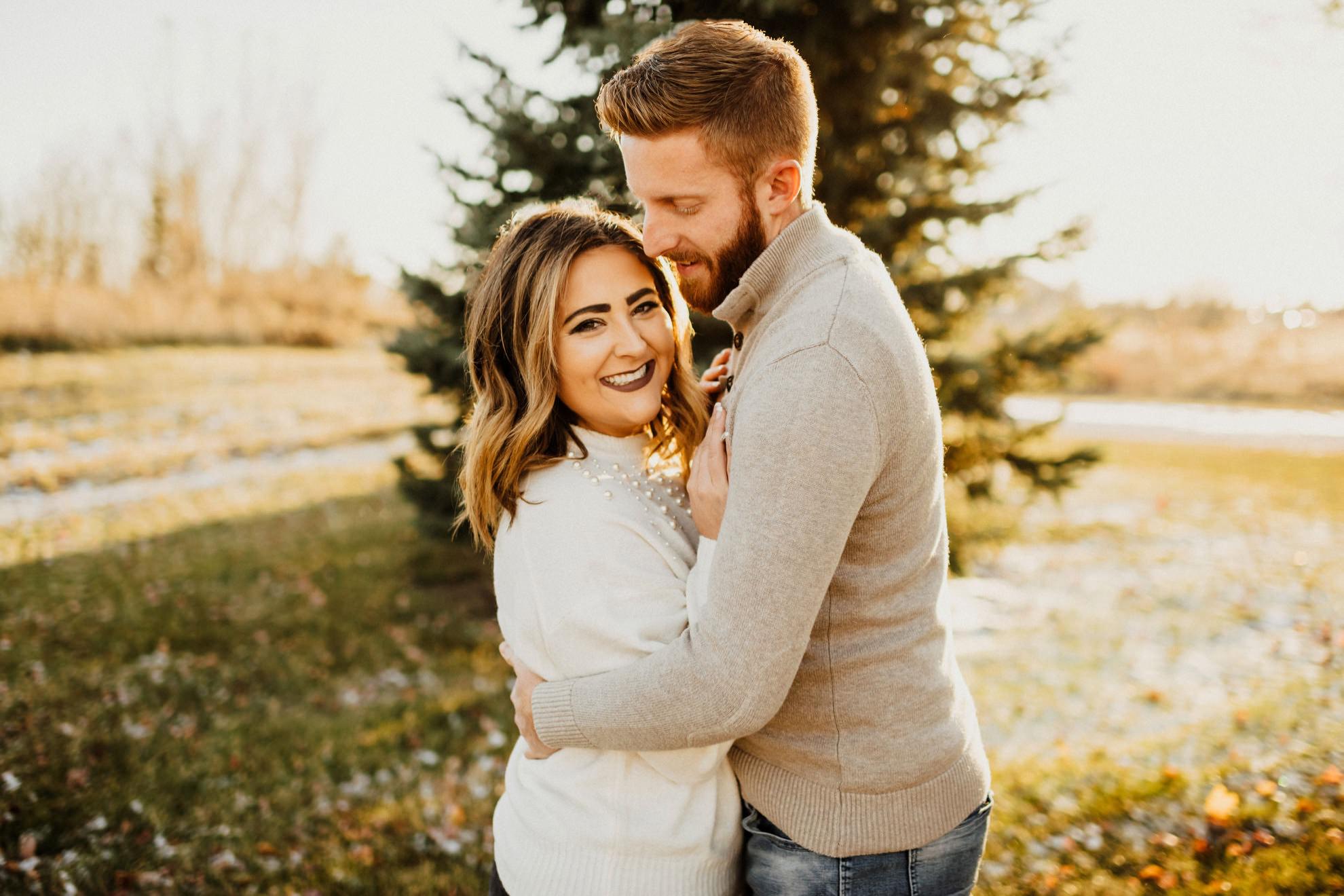 couple smiling and hugging during fall sunset