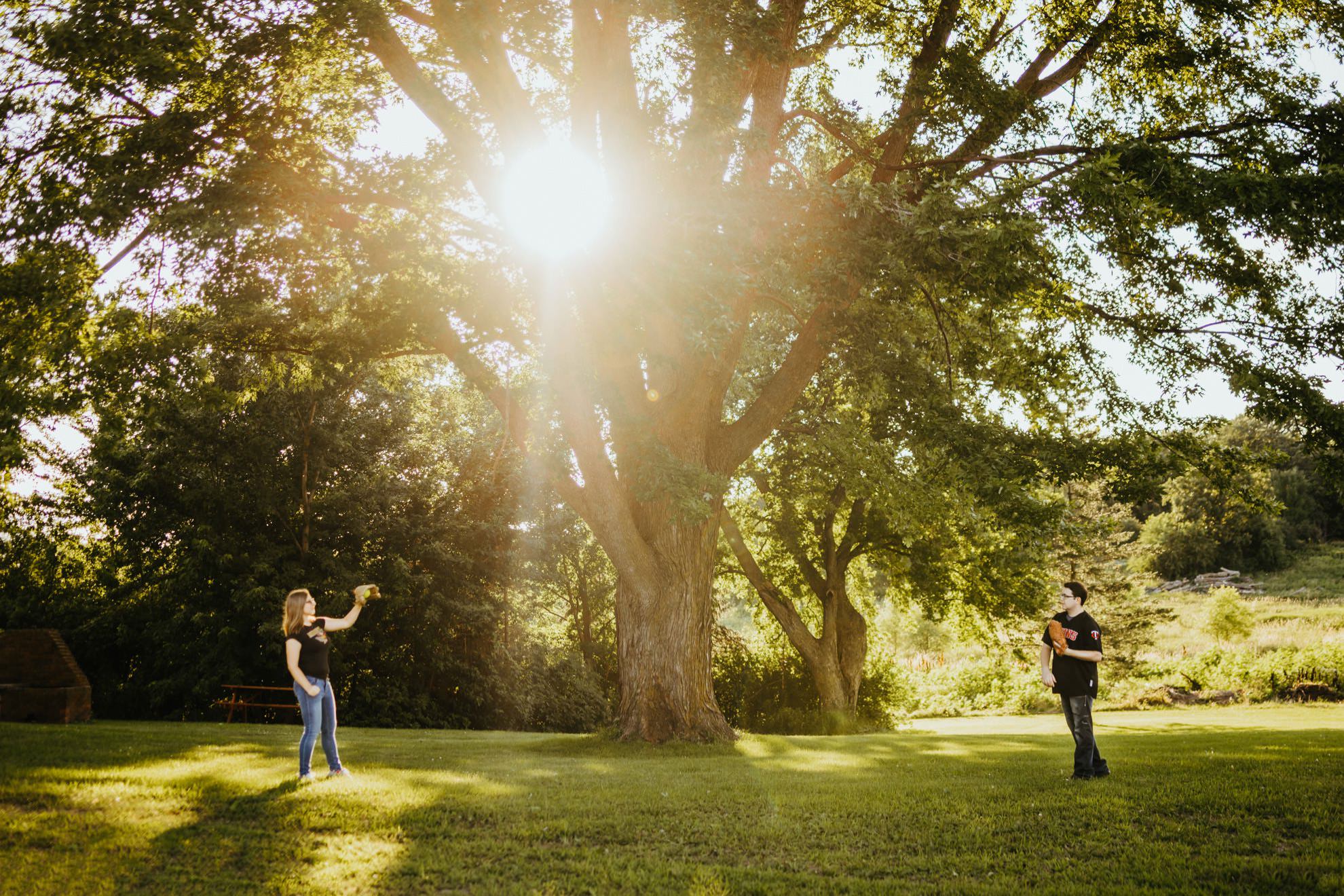 couple throwing baseball during sunset on farm