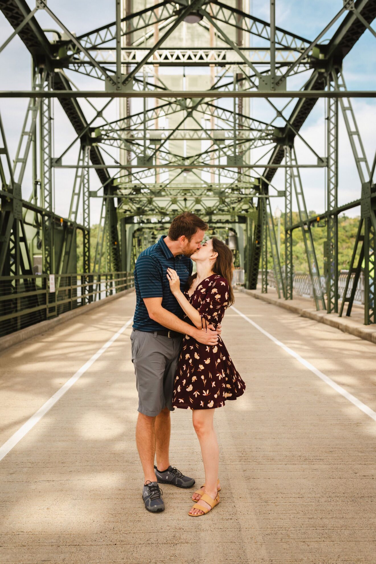 a newly engaged couple kissing on historic bridge in stillwater minnesota