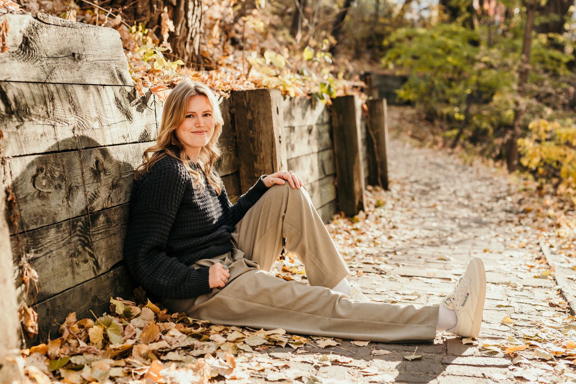 woman sitting on trail during fall for a headshot