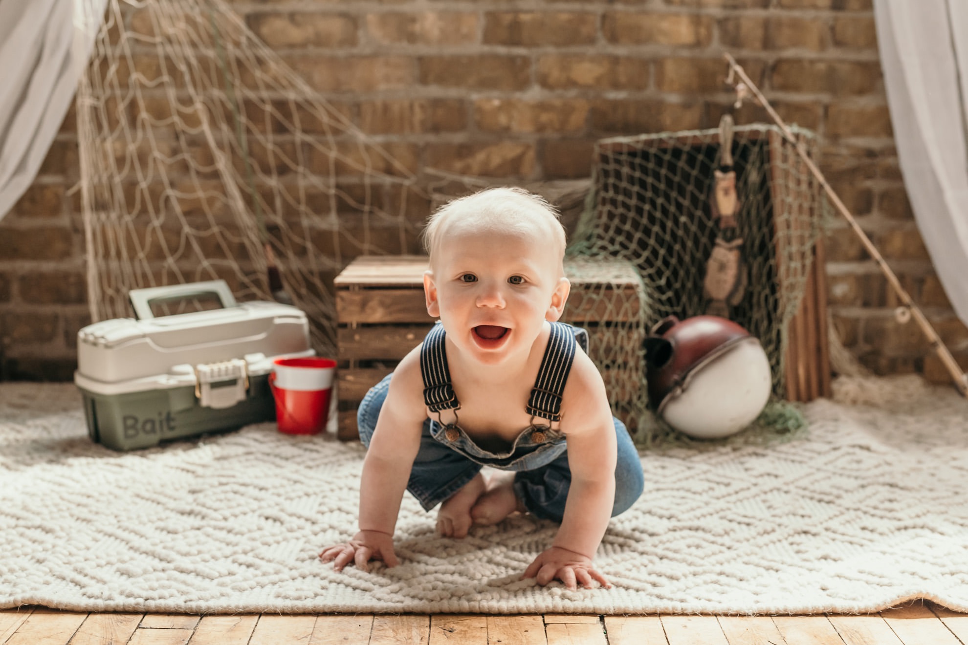 one year old photoshoot of baby boy with fishing props