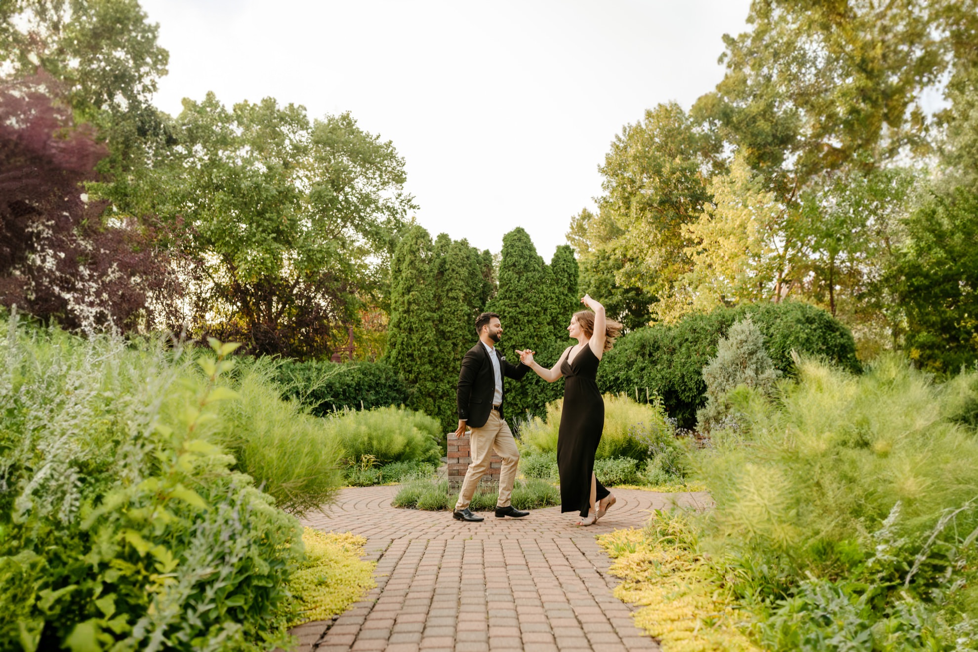 engagement photo of couple swing dancing at centennial lakes park in edina minnesota